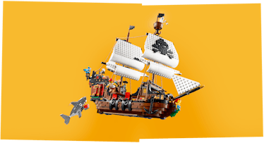 A fully built LEGO 3-in-1 Pirate Ship's boat on an orange background