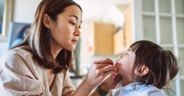 A mother gives her daughter an at-home COVID test.