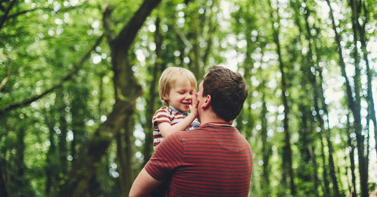 dad and son smiling at each other in nature