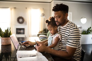 dad looking Stimulus check daughter on his lap