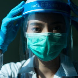 A doctor wear a mask, face shield, and gloves.