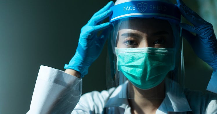 A doctor wear a mask, face shield, and gloves.