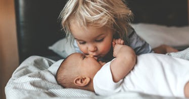 a toddler kisses a baby's face