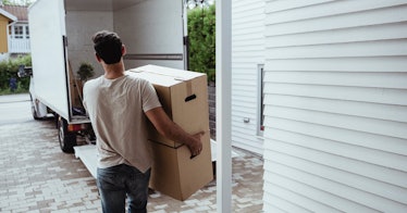 Man carrying boxes to moving truck.