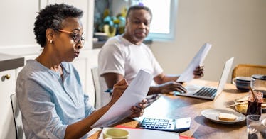 一对老夫妇坐在厨房的桌子边,看看他们的财政状况