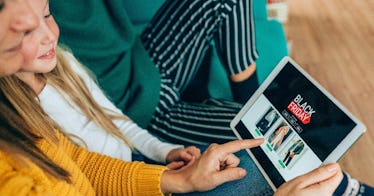 a woman and a child look at their ipad with ads