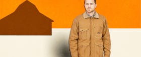 man wearing the Patagonia Iron Forge Hemp Canvas Barn Coat in front of an orange and white backgroun...