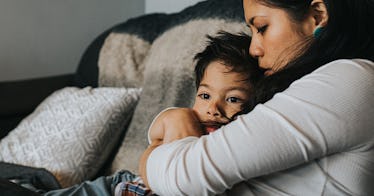 a mother protectively holds her child