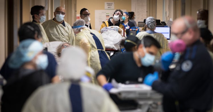 Many people wearing masks in an overcrowded emergency room.