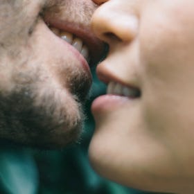 A close-up of a man and a woman's mouths about to kiss