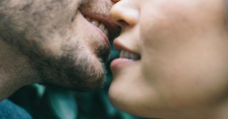 A close-up of a man and a woman's mouths about to kiss