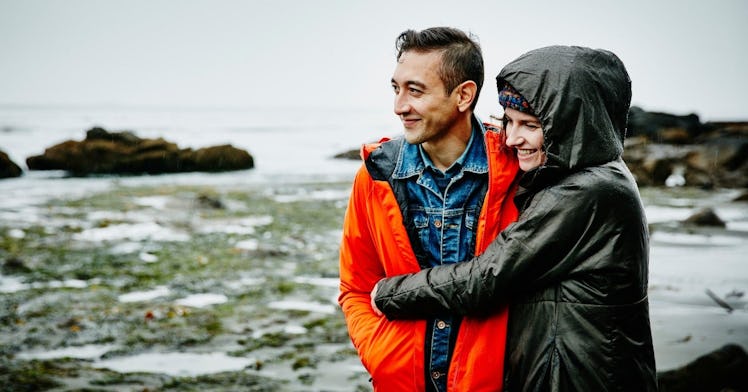 Man-and-woman-embracing-on-rainy-beach