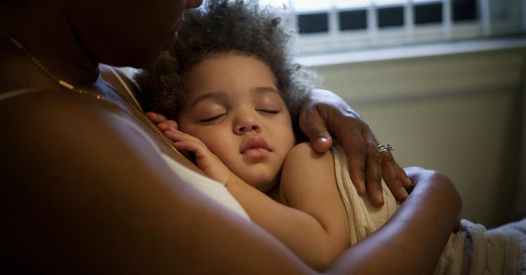 A small girl sleeping on their mother's chest