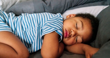 一个穿着条纹连体衣的孩子睡着了。