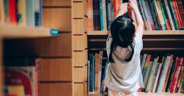 girl at the library grabbing a book