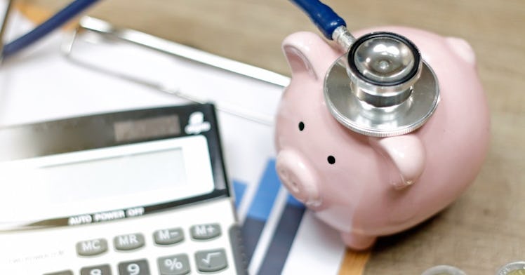 a piggy bank with a stethoscope, calculator and financial forms