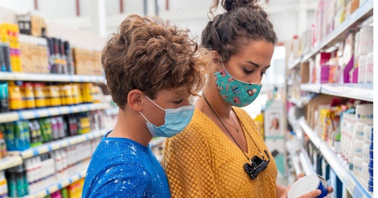 A mom and her son are in a drug store with masks on.