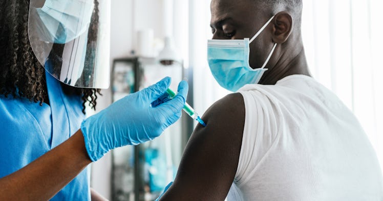 A healthcare provider gives a man a COVID booster shot.t vaccine