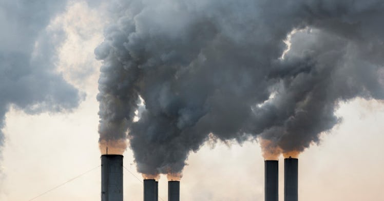 Smokestacks release dark gray clouds of gas.