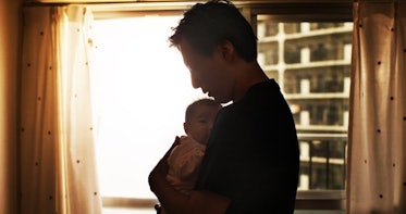 爸爸抱着小婴儿，光线从窗户透进来