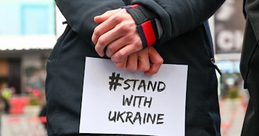 在纽约的乌克兰抗议活动中，一双手举着写着“与乌克兰站在一起”的牌子