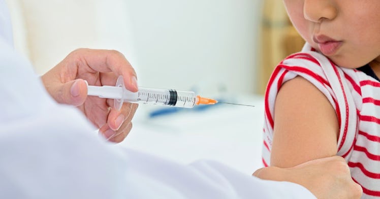A young boy under 5 years old receives a COVID vaccine.