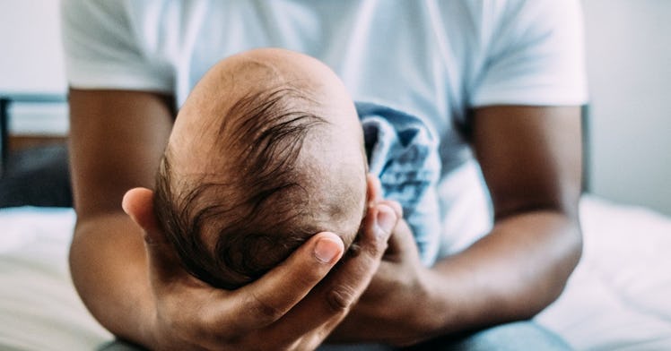 a dad holds his baby on his lap