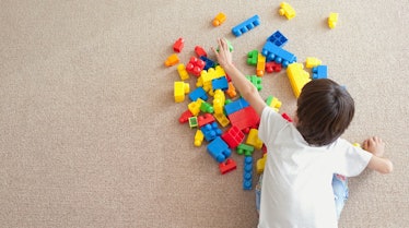 A child plays with colorful blocks on the floor.