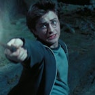 Harry Potter outside shooting light off a wand as he recites a Harry Potter spell.