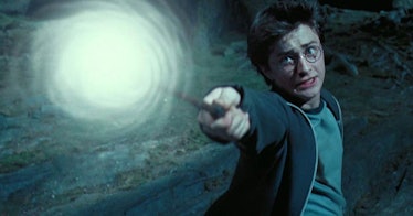 Harry Potter outside shooting light off a wand as he recites a Harry Potter spell.