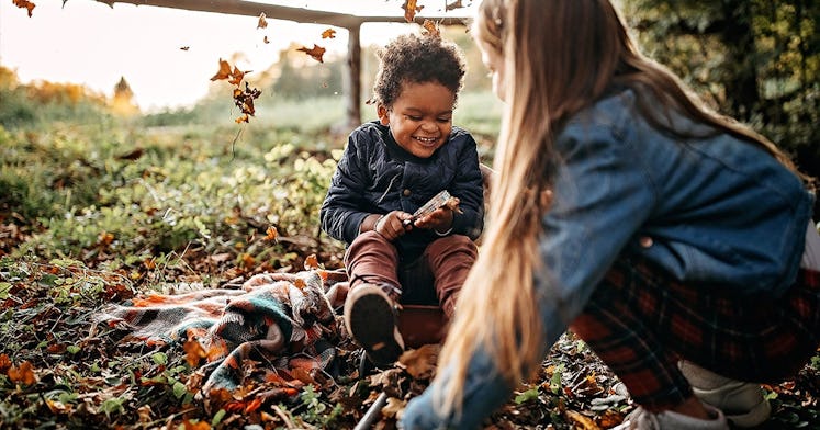 a boy and a girl play games outside together laughing and surrounded by signs of fall