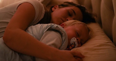 closeup of a sleeping mother with her arm draped over her co-sleeping child