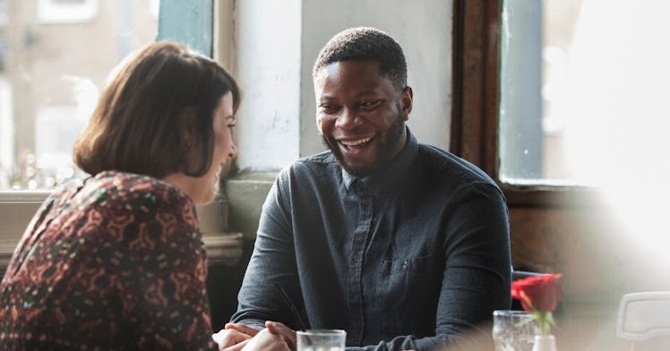 Couple laughing and talking in a booth at a bar
