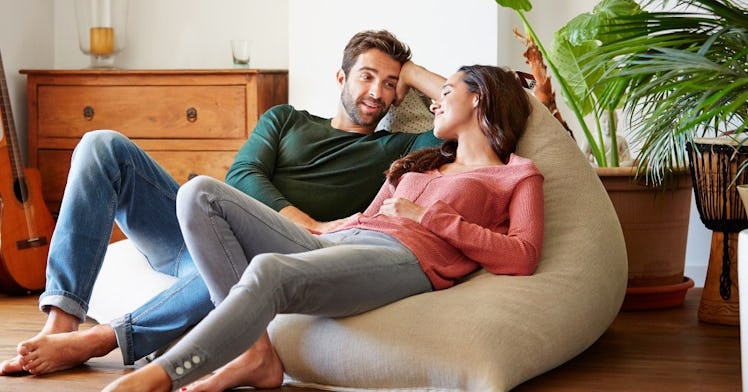 Man and woman talking while seated on beanbag chair