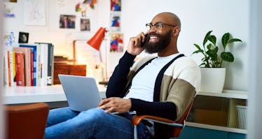 Man sitting in office talking on phone with big smile on his face