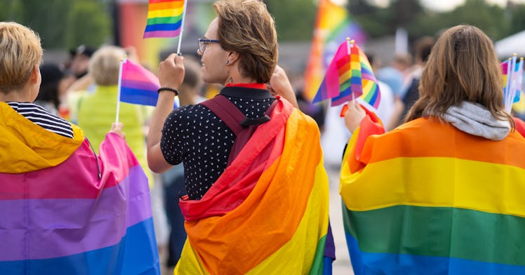 Trans youth march while holding rainbow flags.