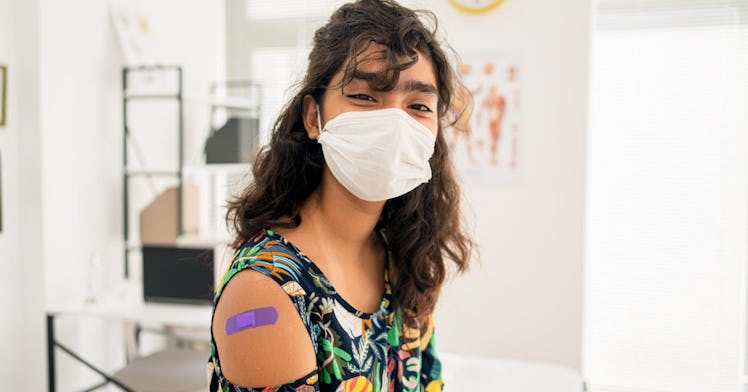 A kid who has been vaccinated has a mask on and a smile.