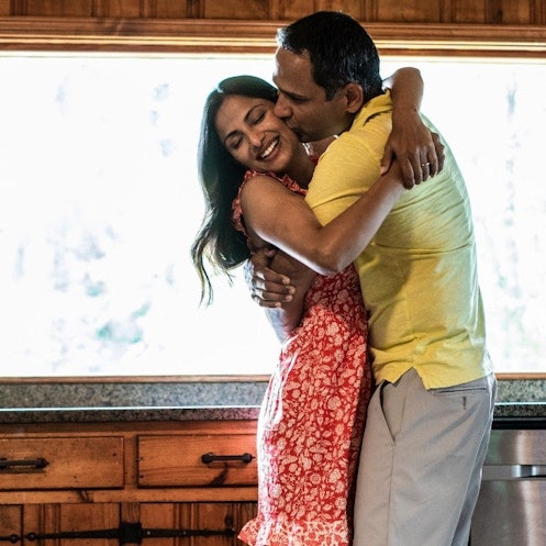 Happy husband and wife embracing in their kitchen