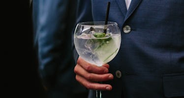 西装男子拿着杜松子酒加黄瓜