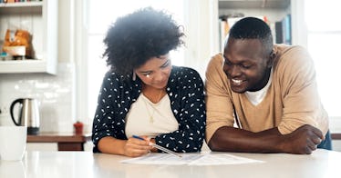 a Black couple looks over their taxes happily