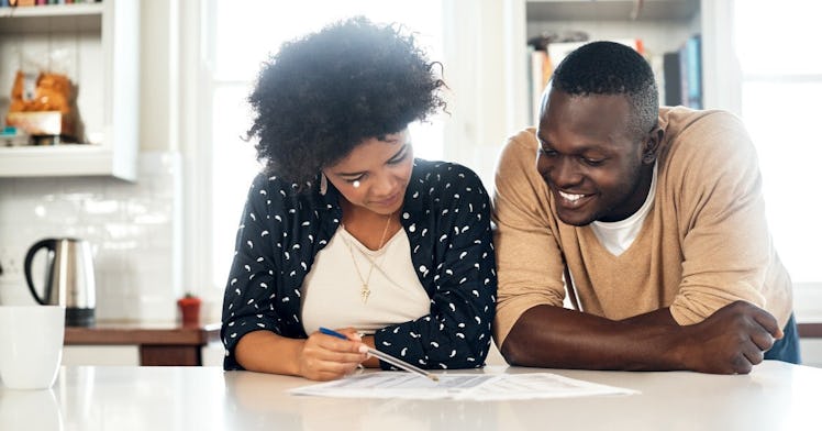 a Black couple looks over their taxes happily