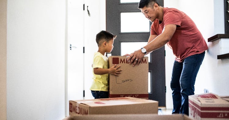 A dad and his son empty boxes of a house they just moved into