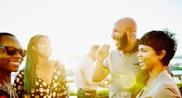Charming friends sharing a drink and laughing at a party