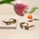 Ray-Ban Stories Wayfarer glasses on a white table with tulips above them as the fail-proof mother da...