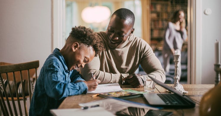 A dad helps his son do homework.