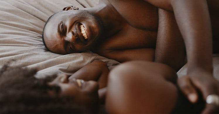 Man grinning in bed as he talks to his wife