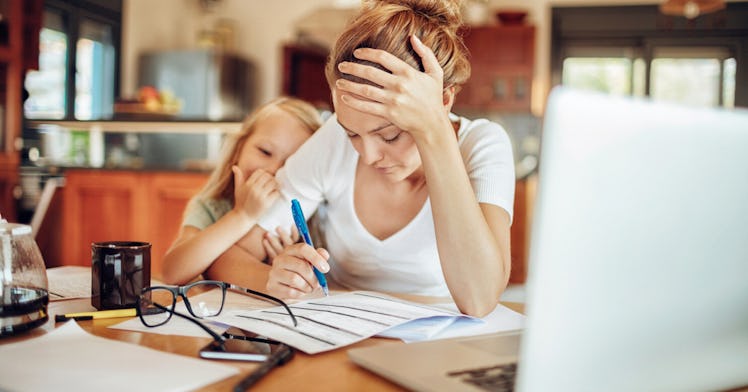 A single mom does work at home with her daughter in the same room.