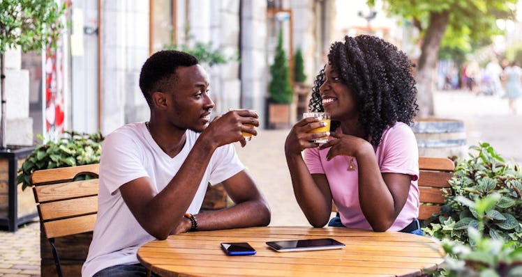 Couple sitting outside at a table drinking and talking