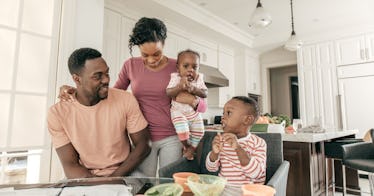 a family sits together at a kitchen table and looks over their finances
