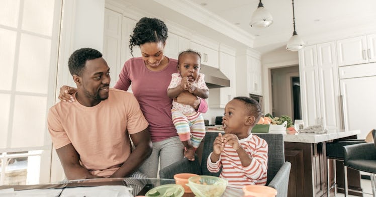 a family sits together at a kitchen table and looks over their finances